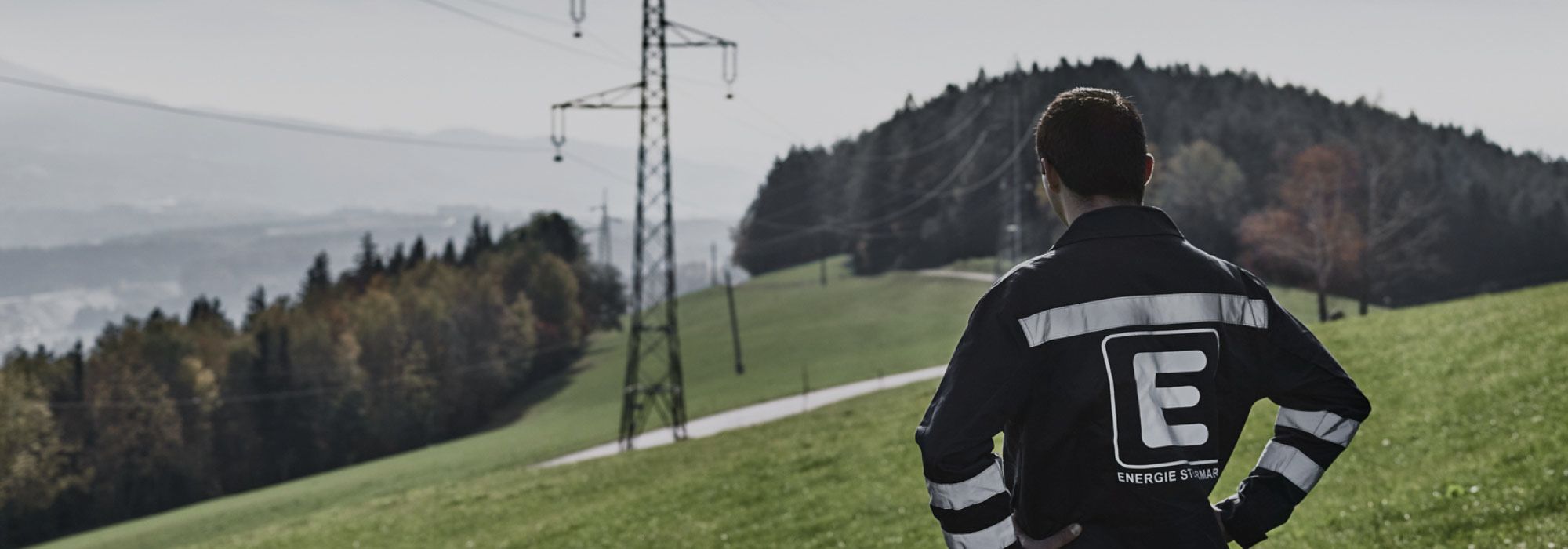 Arbeiter vor einem Strommast