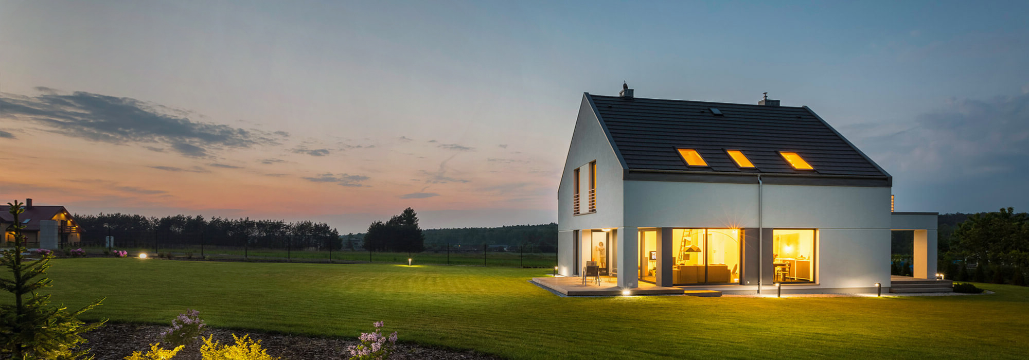 Ein innen beleuchtetes Haus auf einer Wiese