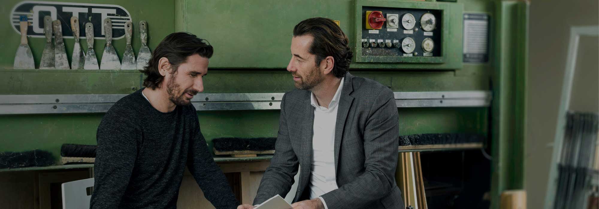 Zwei Personen sitzen vor einer Maschine